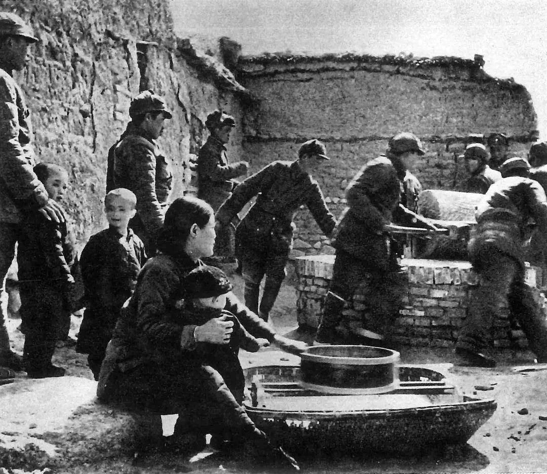 1945年冬，冀中三纵队的战士们在怀来县帮助群众推碾子.jpg