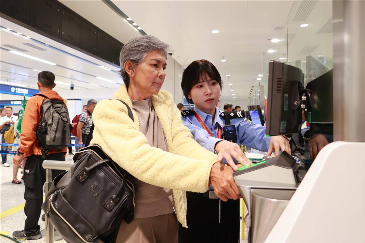 图为移民管理警察协助旅客进行查验.JPG