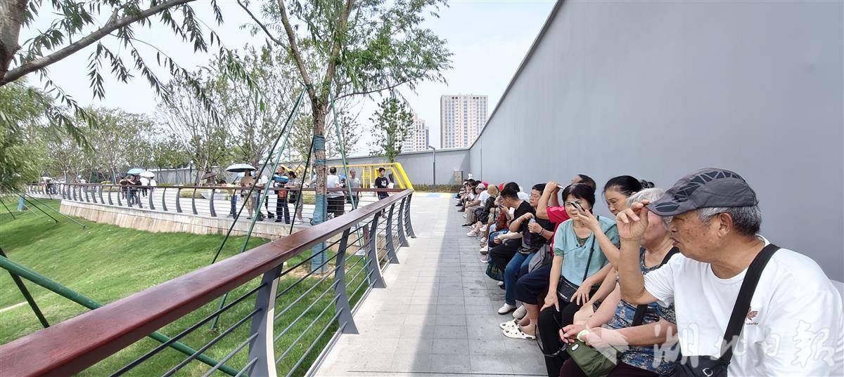 坐在防洪墙下休息的游客，以中老年人为主。4.jpg