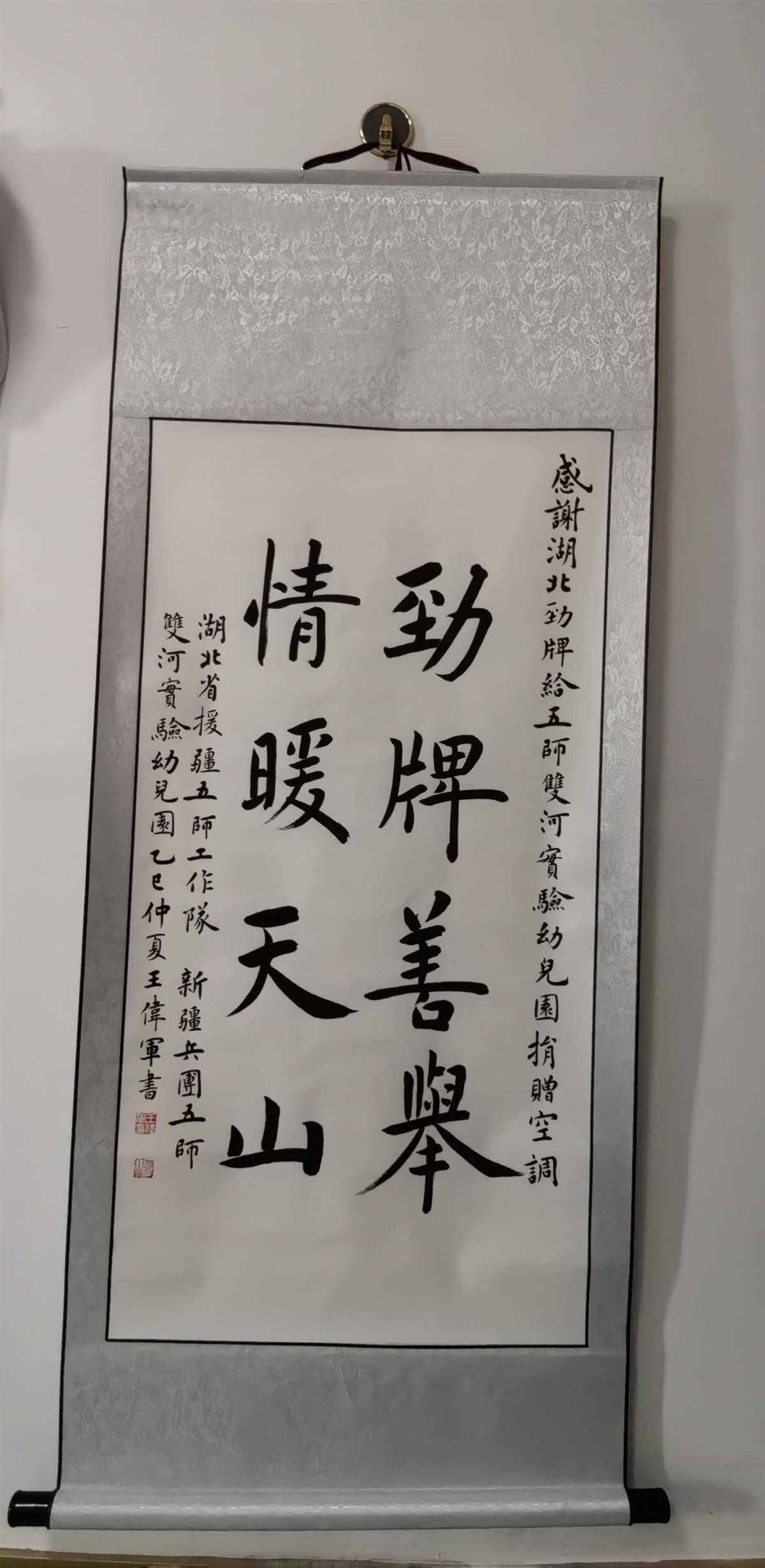 06 20250714湖北省援疆第五师工作队负责人向湖北省劲牌公益慈善基金会代表赠送了书法作品内容“劲牌善举 情暖天山”.jpg
