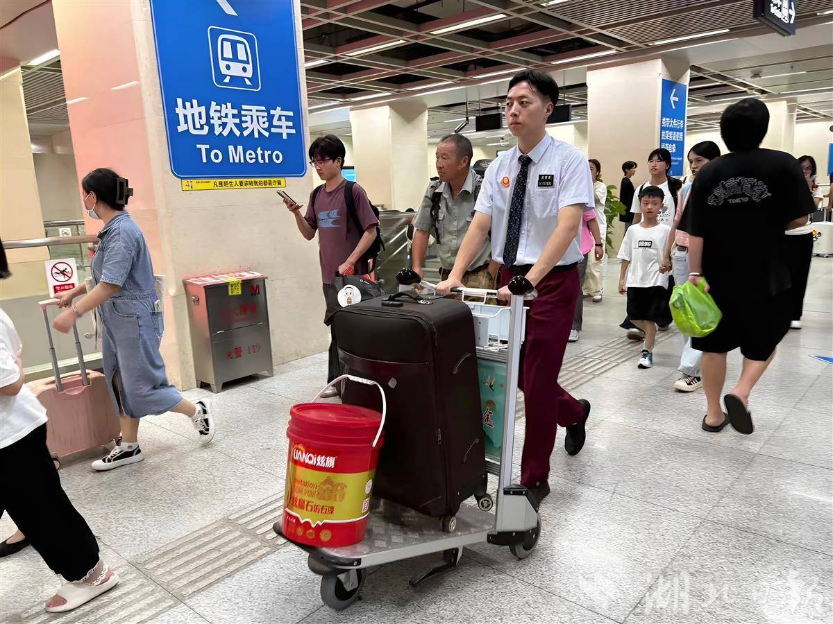双节假期，武汉地铁汉口车站值班员用推车帮乘客转运行李。王晓娟 摄.jpg