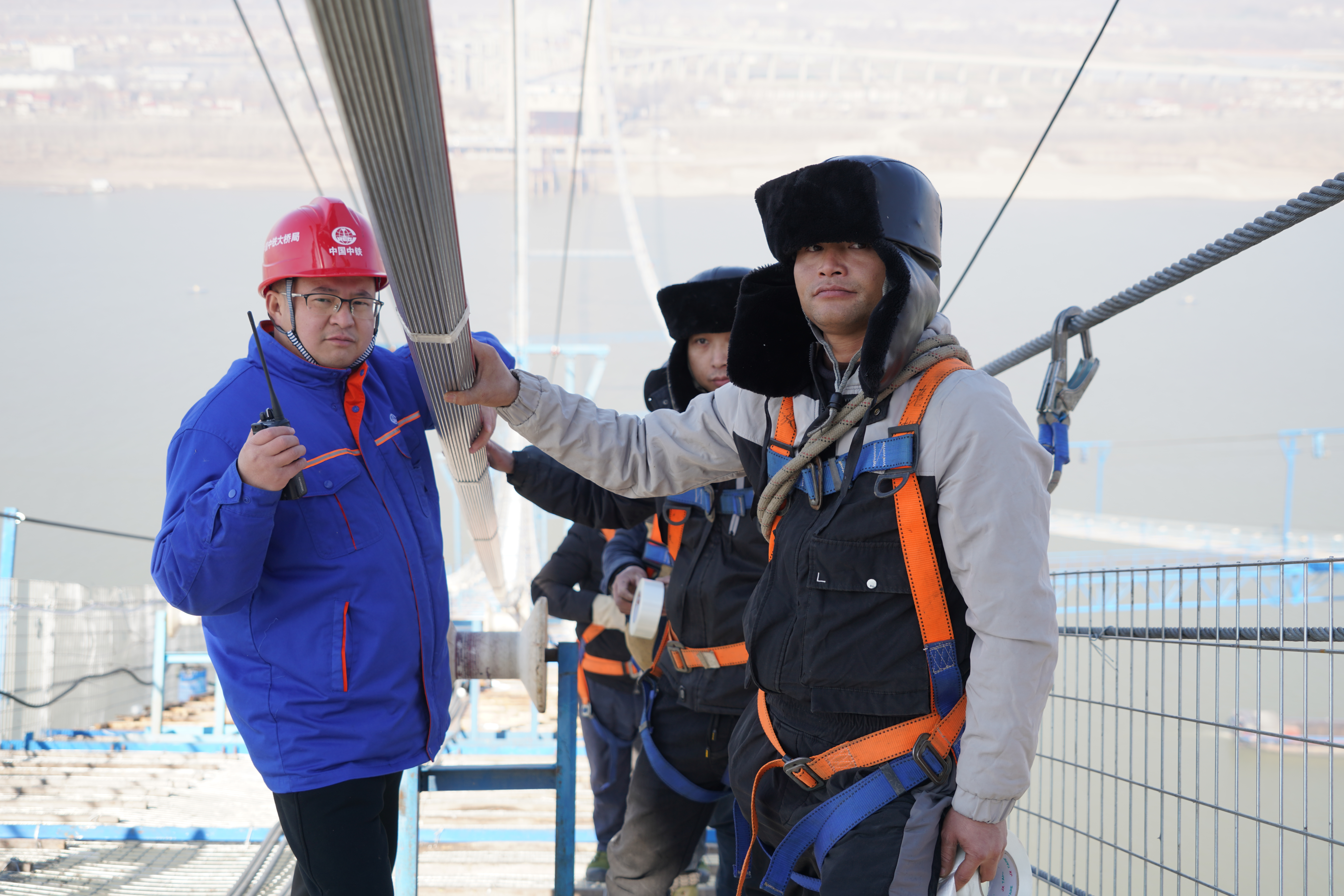 中铁大桥局项目总工程师黄辉在猫道上作业。（通讯员 周瑜  摄）