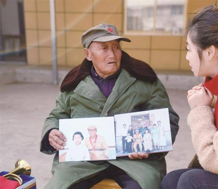         胡大兴老人向记者展示吴克群精心制作的照片。张彩云 摄    