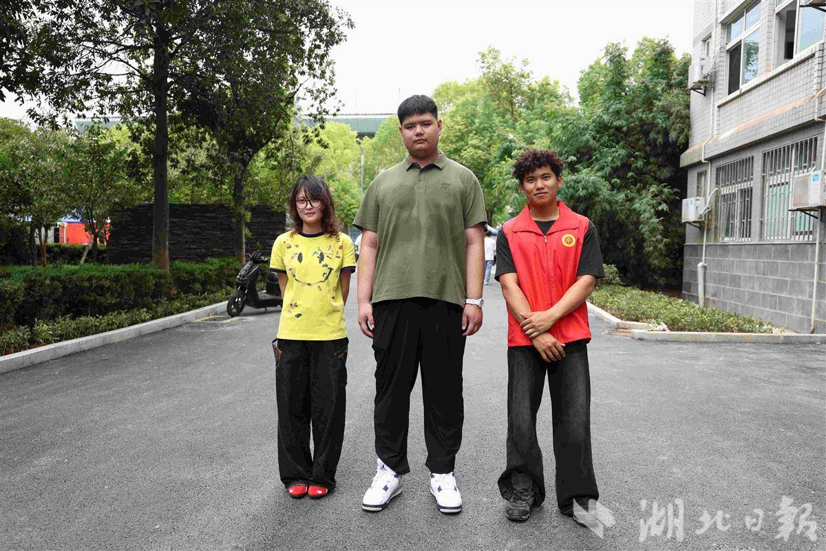 图为2米新生柳兆轩在报到现场和学生志愿者合影 摄影：芮雨欣.JPG