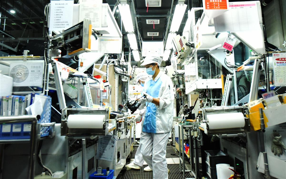 孝感高新区的湖北小糸车灯有限公司车间内,工人在生产线上加工车灯